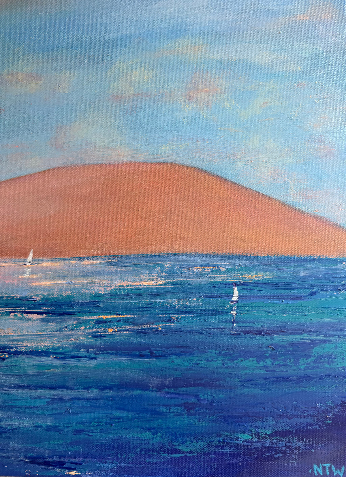 An impressionistic painting of a coastal landscape with a large peach-colored hill or dune against a light blue sky, blue ocean water, and small white sailboats. Includes Artist signature. 